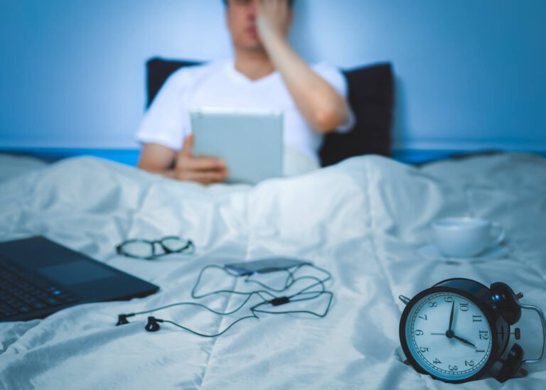 man working in bed at night