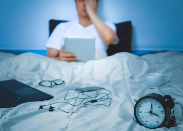 man working in bed at night
