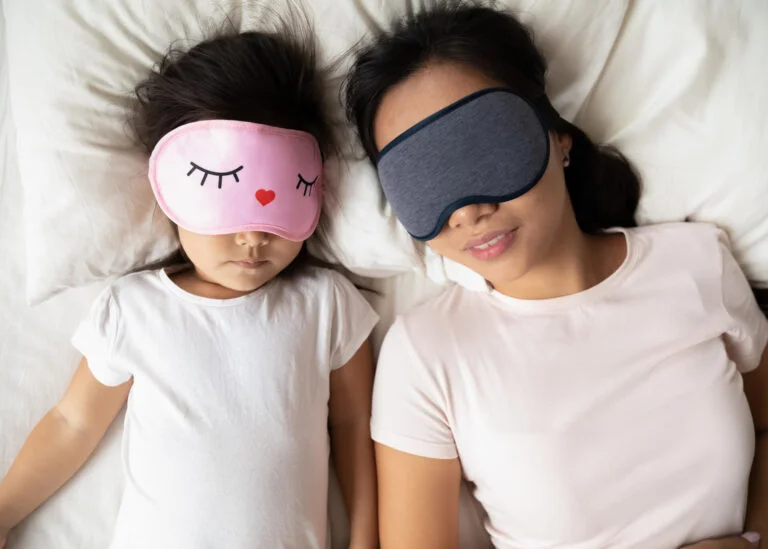 mother and daughter sleeping in bed