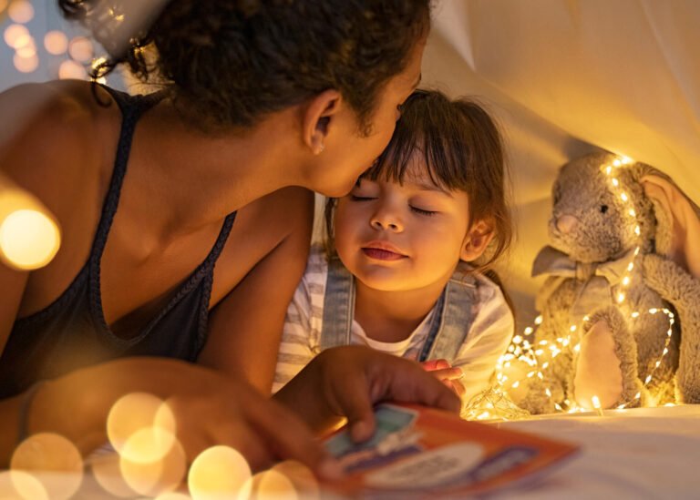 mother kissing daughter good night