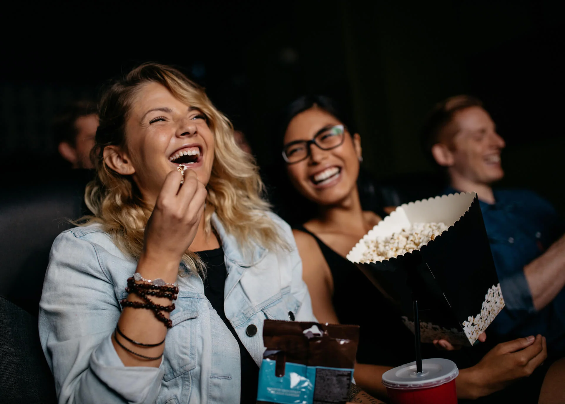 friends in cinema eating popcorn