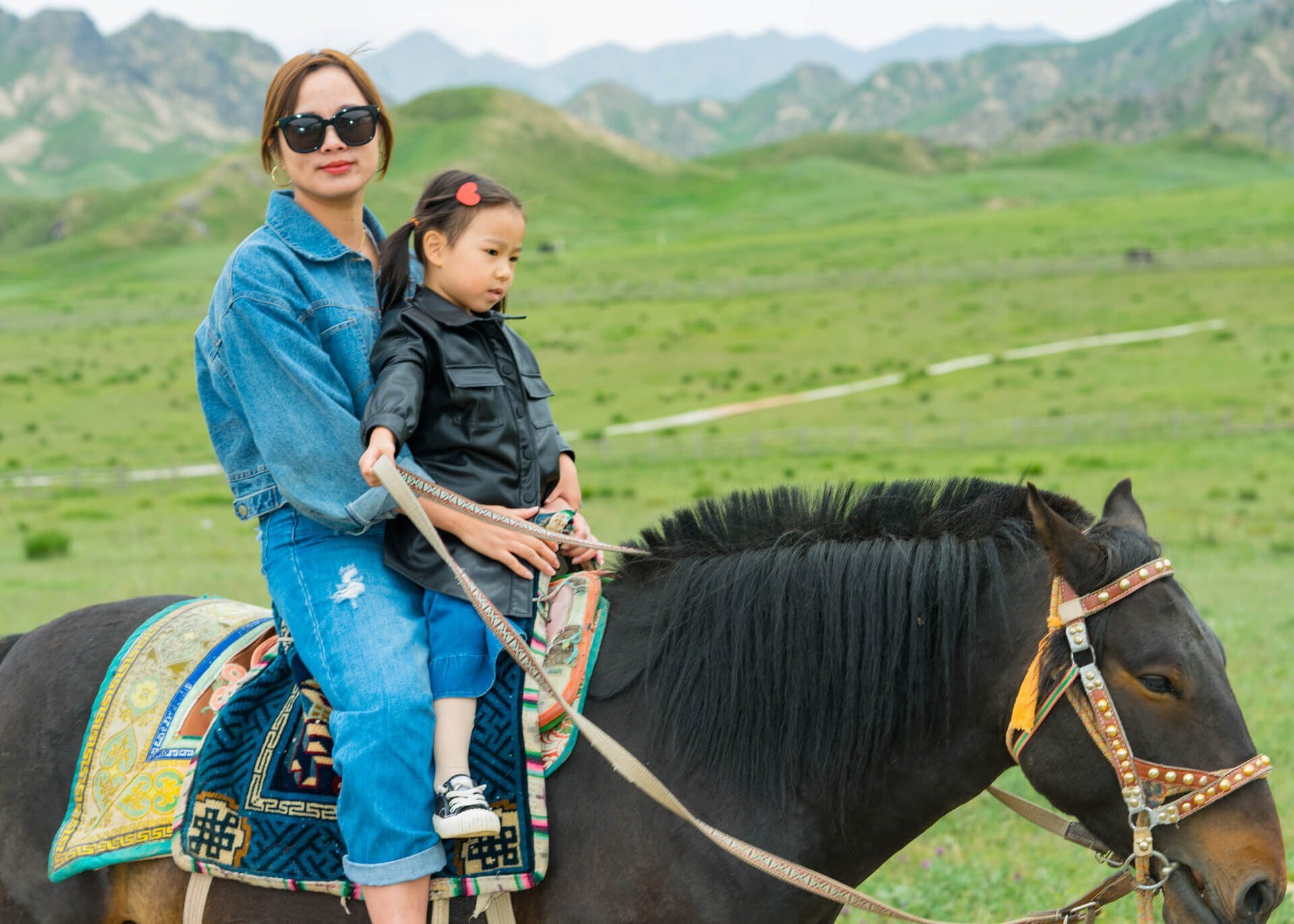 chinese woman riding horse with child