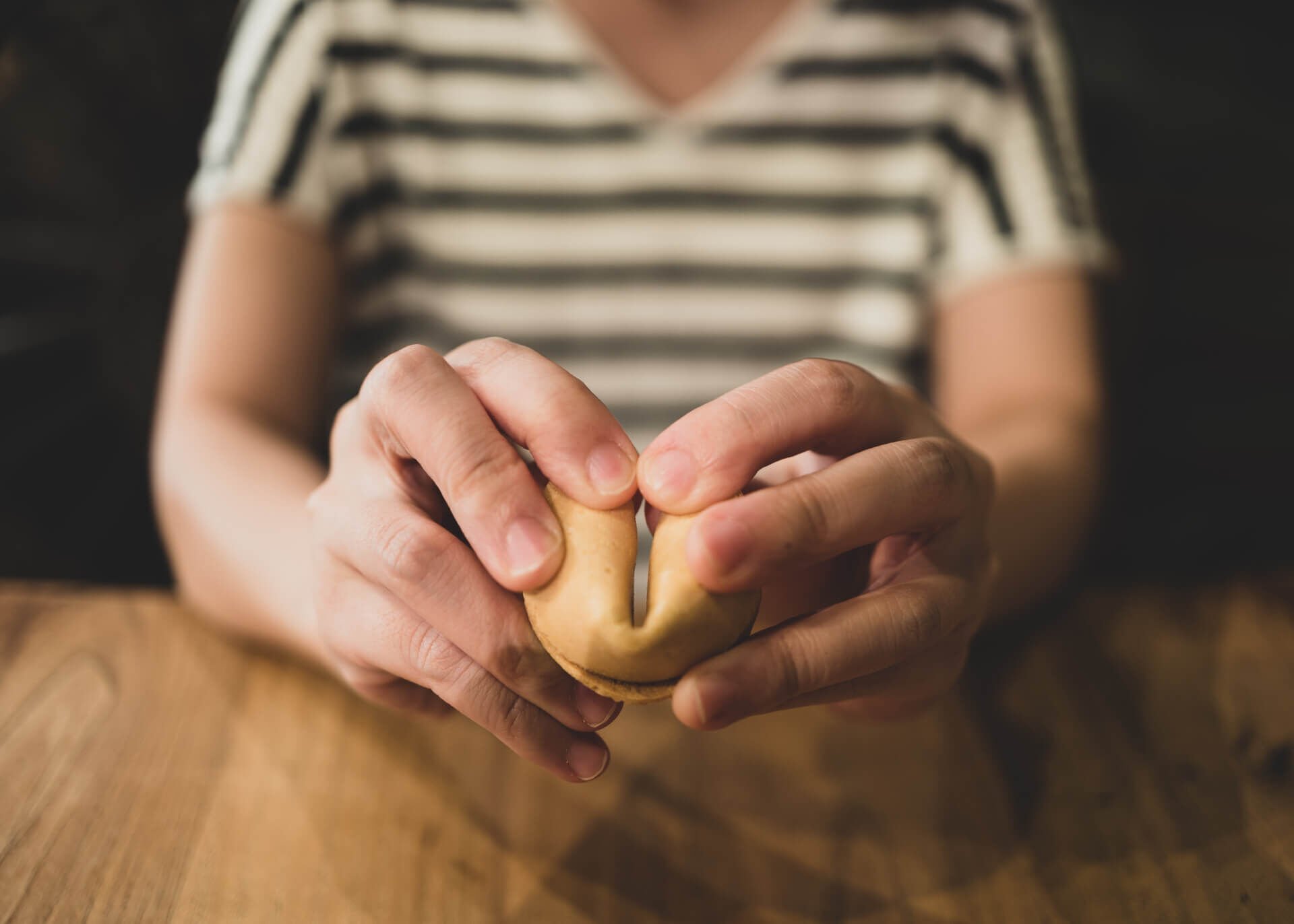 hands breaking fortune cookie