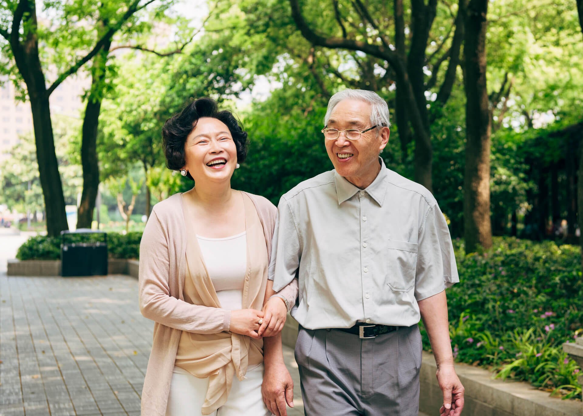 a couple of chinese seniors walking in a park