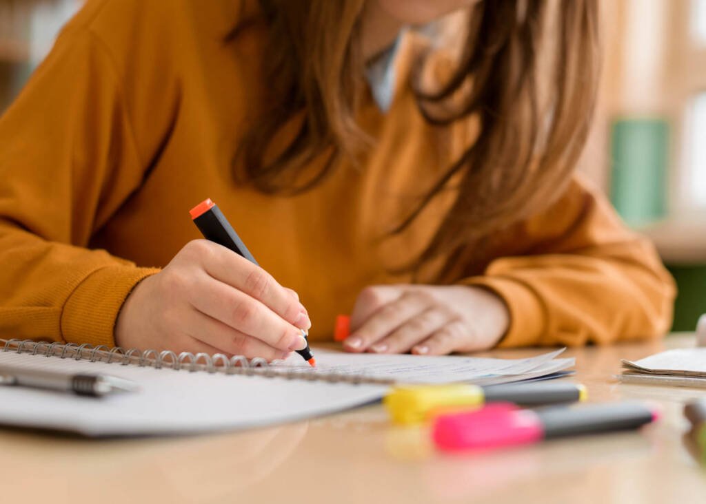 young woman writing in a notebook studying chinese