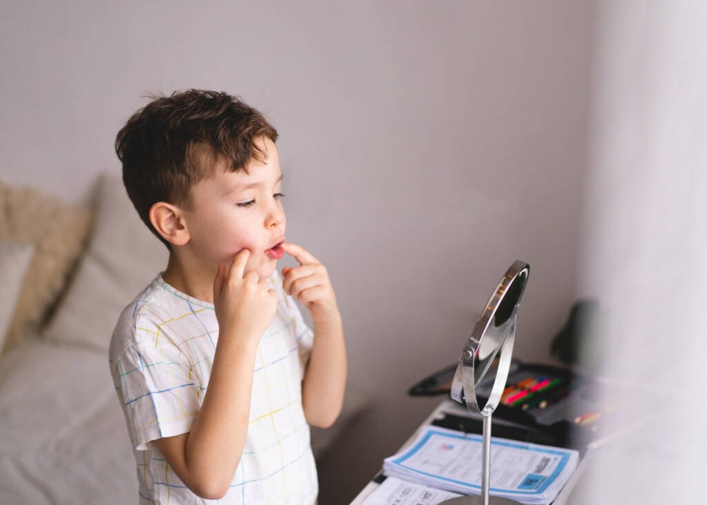 child practicing pronunciation in front of mirror