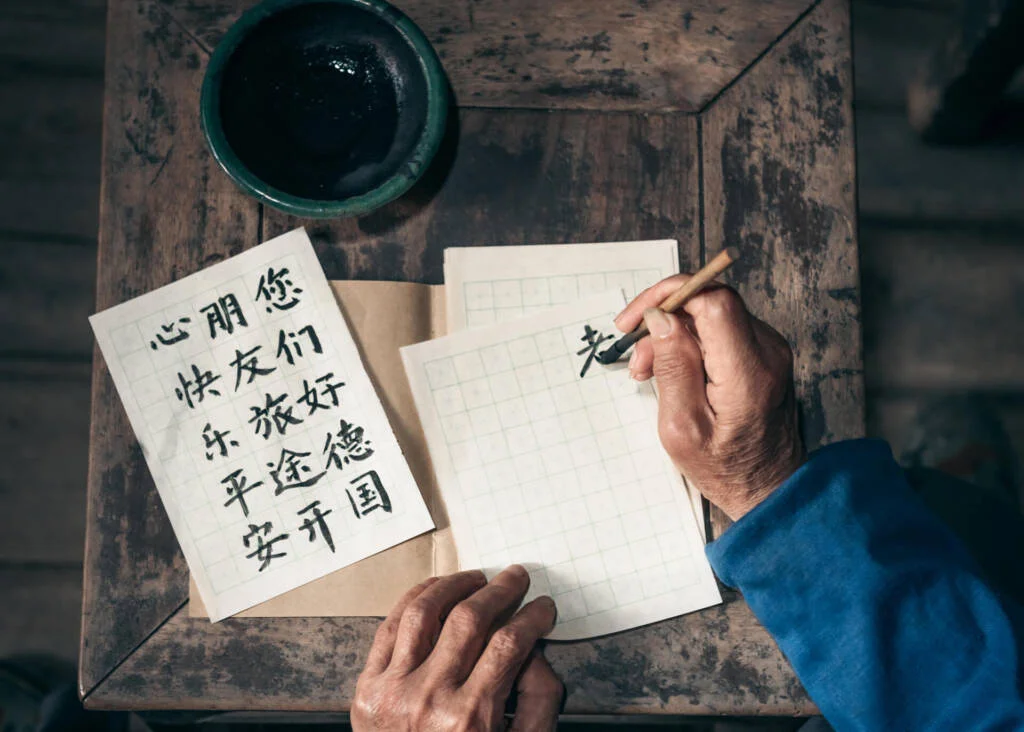 man writing chinese calligraphy