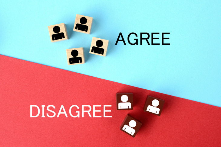 wooden-blocks-with-person-pictogram-on-red-and-light-blue-background-with-agree-and-disagree-words