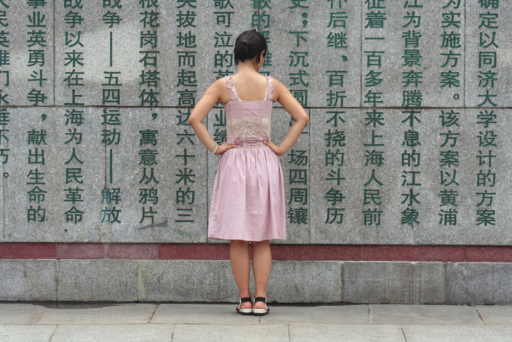 young-chinese-woman-reading-characters-on-wall