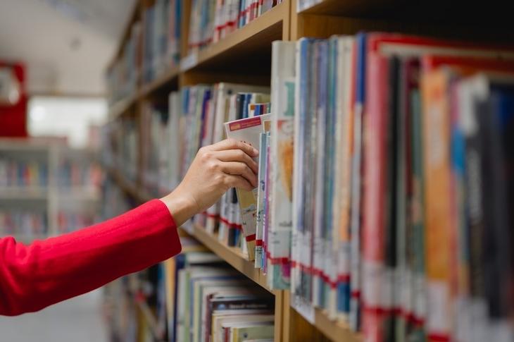 adult-learning-education-concept-woman-reaching-for-a-book