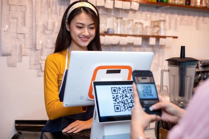 asian-women-barista-smiling-while-accepting-mobile-payment