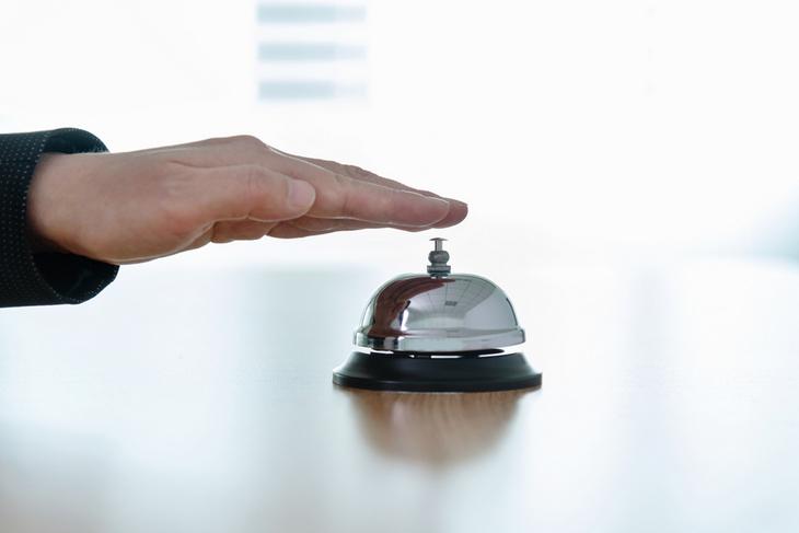 businessperson-hand-using-hotel-bell